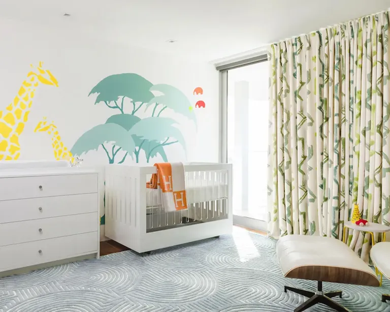 Детская комната с рисунками жирафов на стене