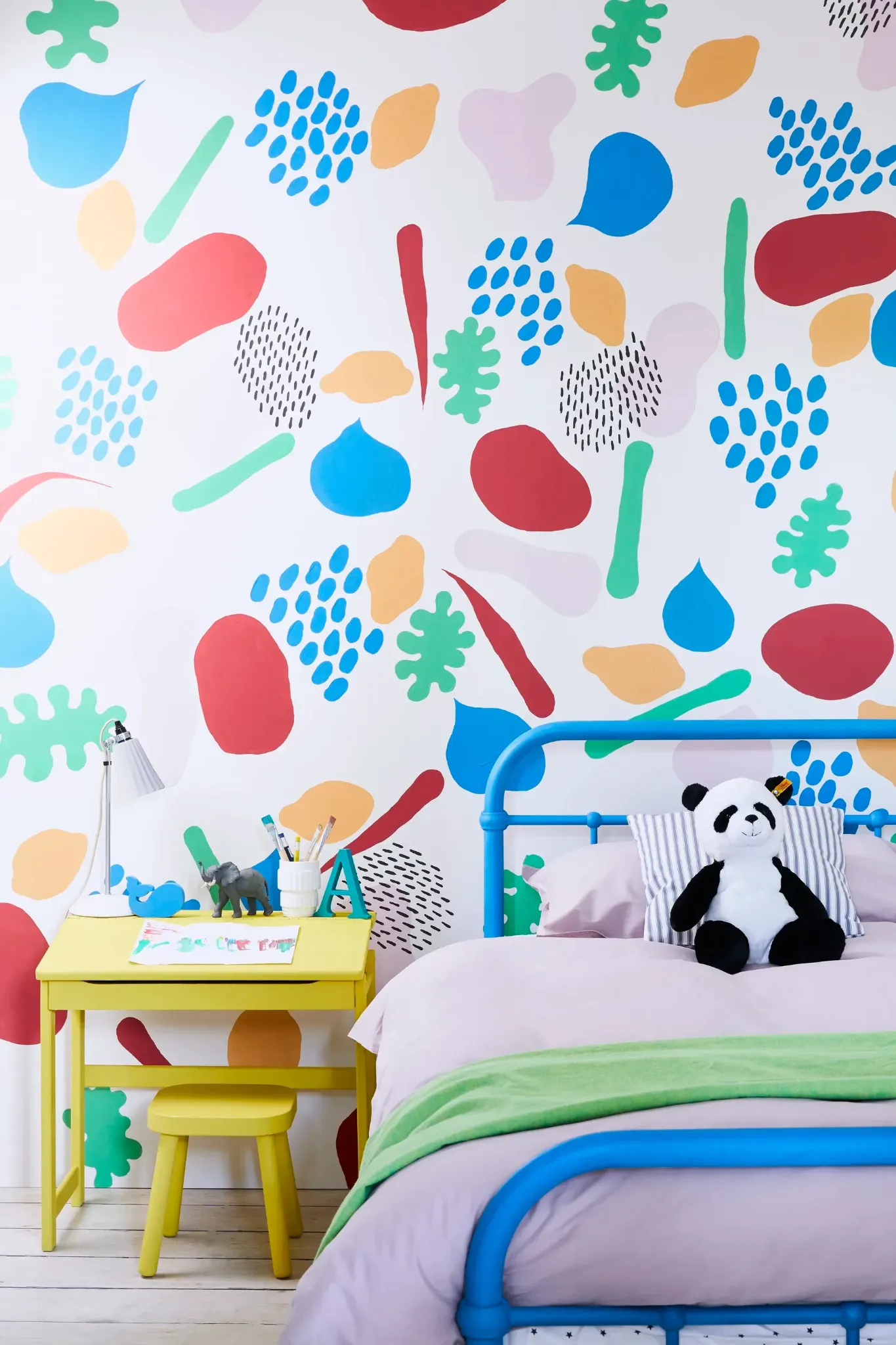 Детская комната с яркой стеной и кроватью