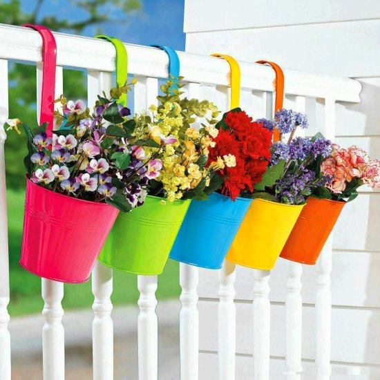 Разноцветные горшки с цветами на балконе