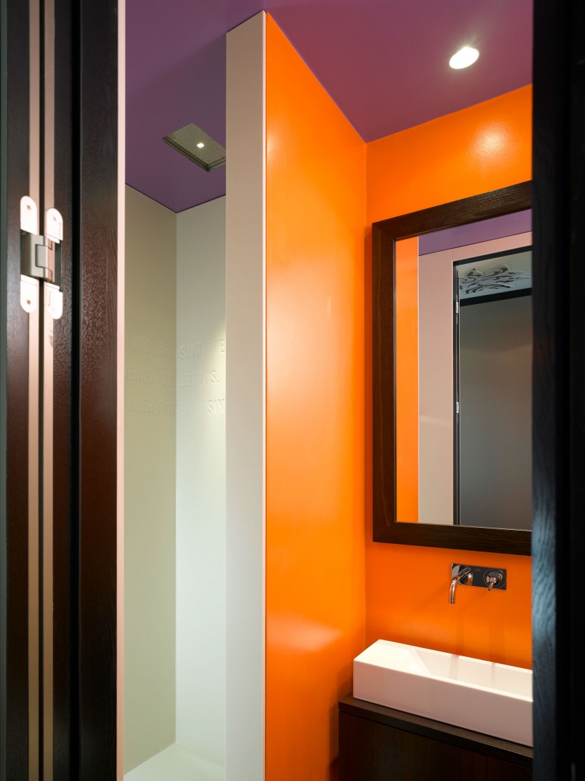 Сочный оранжевый цвет в контрасте с лиловым потолком санузла