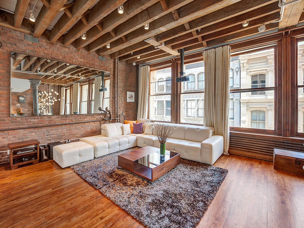 Белый угловой диван в гостиной апартаментов Soho Loft в Нью-Йорке