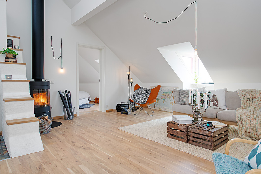 Интерьер гостиной в светлых тонах в небольшой квартире на чердаке в Швеции
