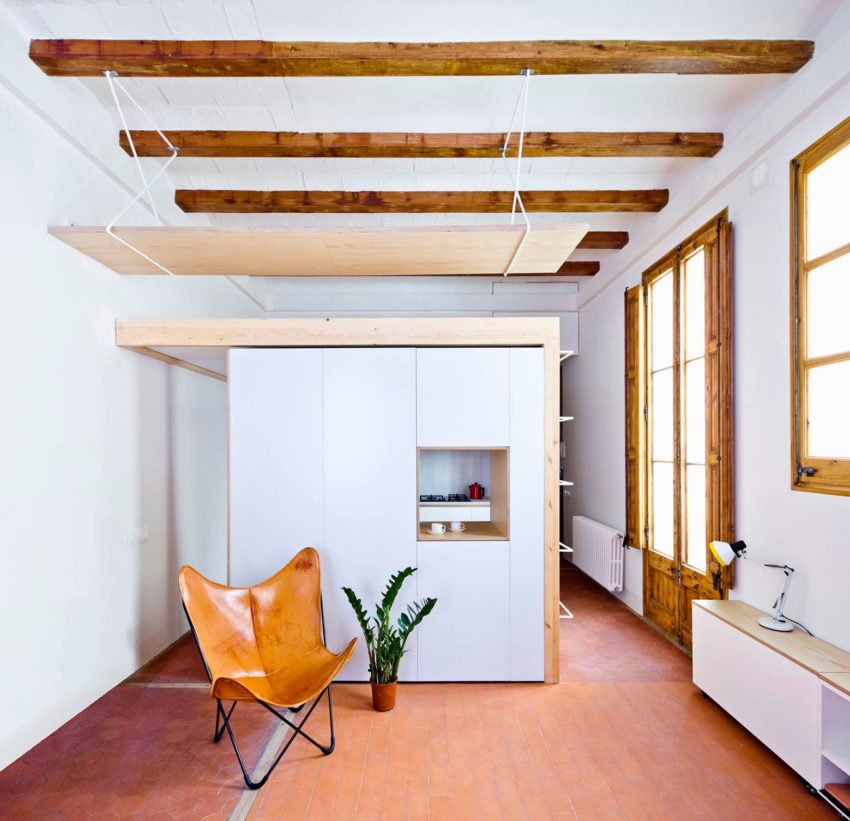 Проект реконструкции квартиры - деревянные балки на потолке и дизайнерское кресло в гостиной
