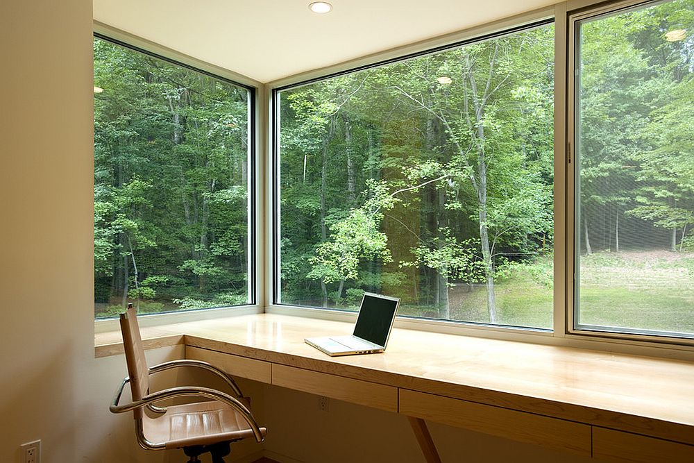 Большие окна в домашнем мини-офисе с видом на лес