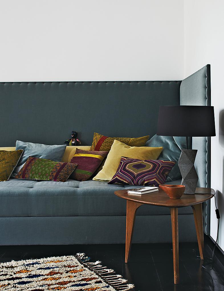 Разноцветные декоративные подушки на сером диване гостиной