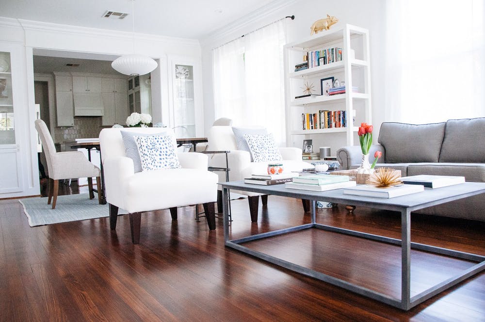 Элегантный интерьер квартиры - белая мебель и деревянный пол в гостиной