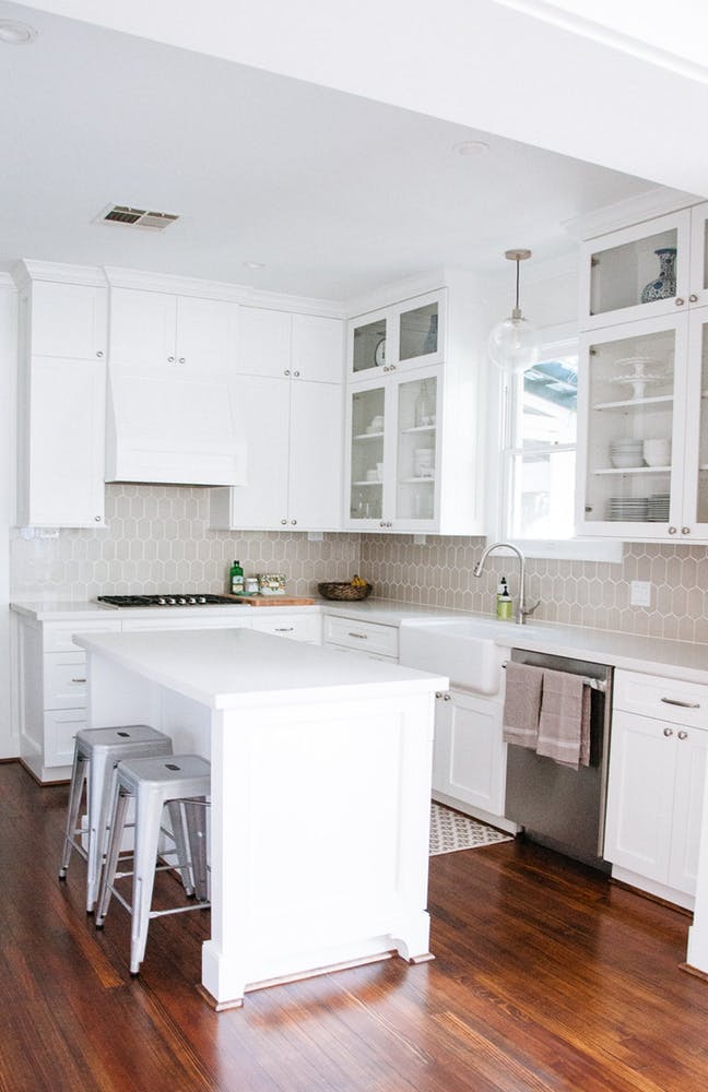 Элегантный интерьер белой кухни с деревянным полом