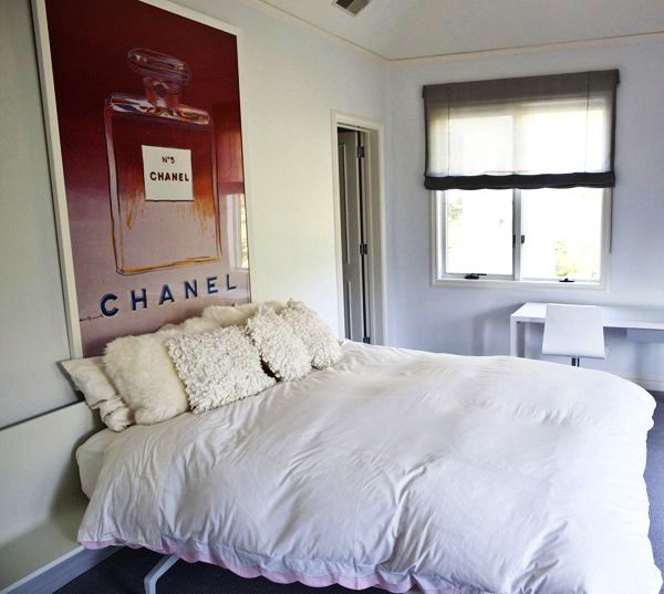 Постер Chanel на стене за кроватью