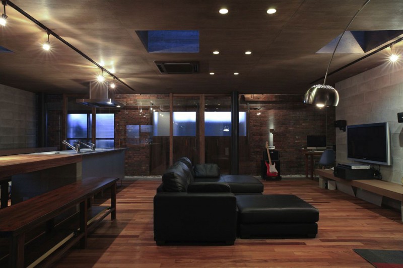 Черный кожаный диван в гостиной в лофт-квартире
