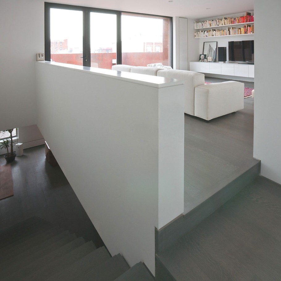 Лестница, которая ведёт из кухни в гостиную в двухуровневой квартире в Бруклине