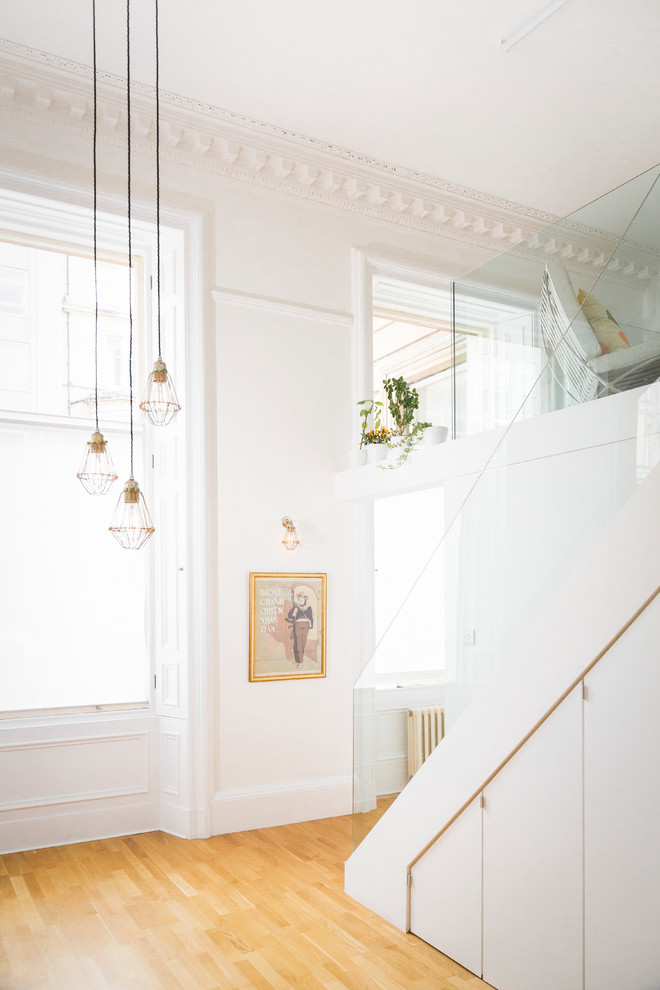 Интерьер квартиры с высокими потолками: стеклянные перила лестницы