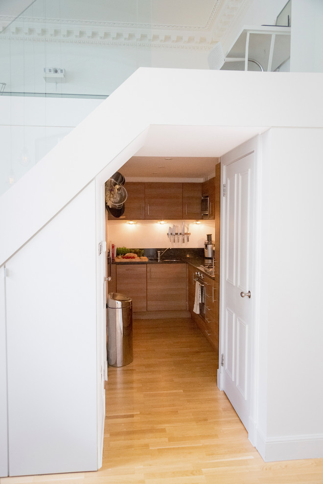 Интерьер квартиры с высокими потолками: кухня под лестницей