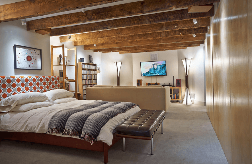 Интерьеры комнаты в подвале - светлая спальня с деревянными потолочными балками