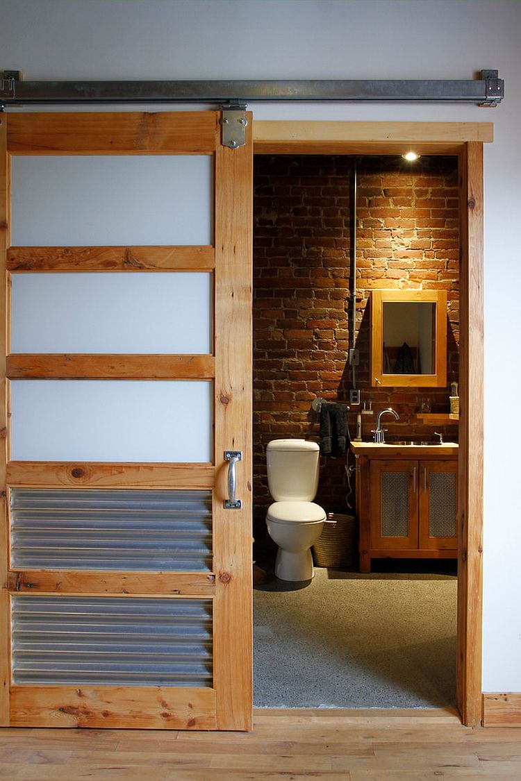 Кирпичная стена и деревянная мебель в небольшой ванной