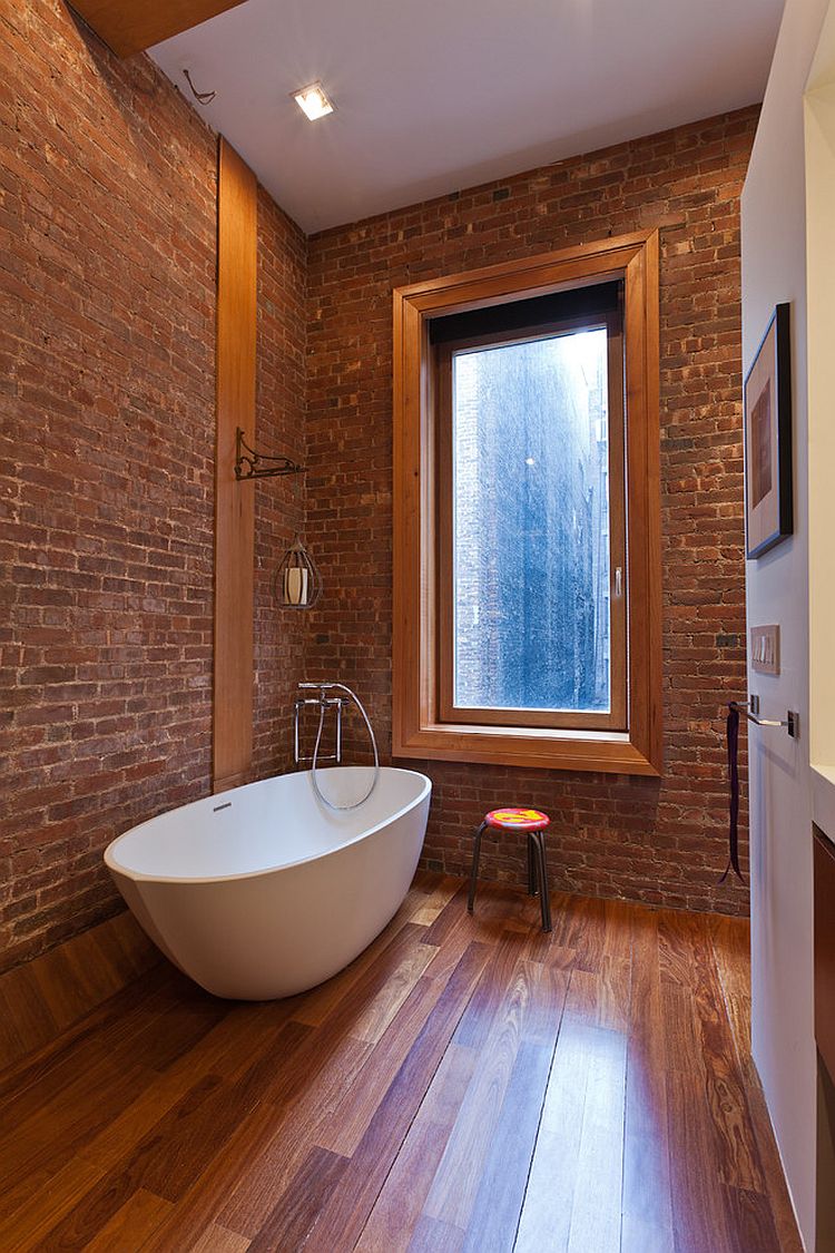 Кирпичная стена и деревянный пол в небольшой ванной в индустриальном стиле