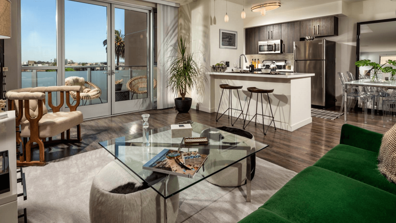 Квартиры в Лос-Анджелесе - стеклянный столик и зелёный бархатный диван в гостиной