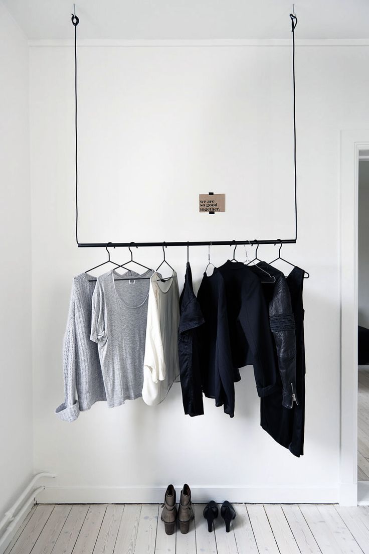 Подвесная открытая вешалка для одежды черного цвета в спальне