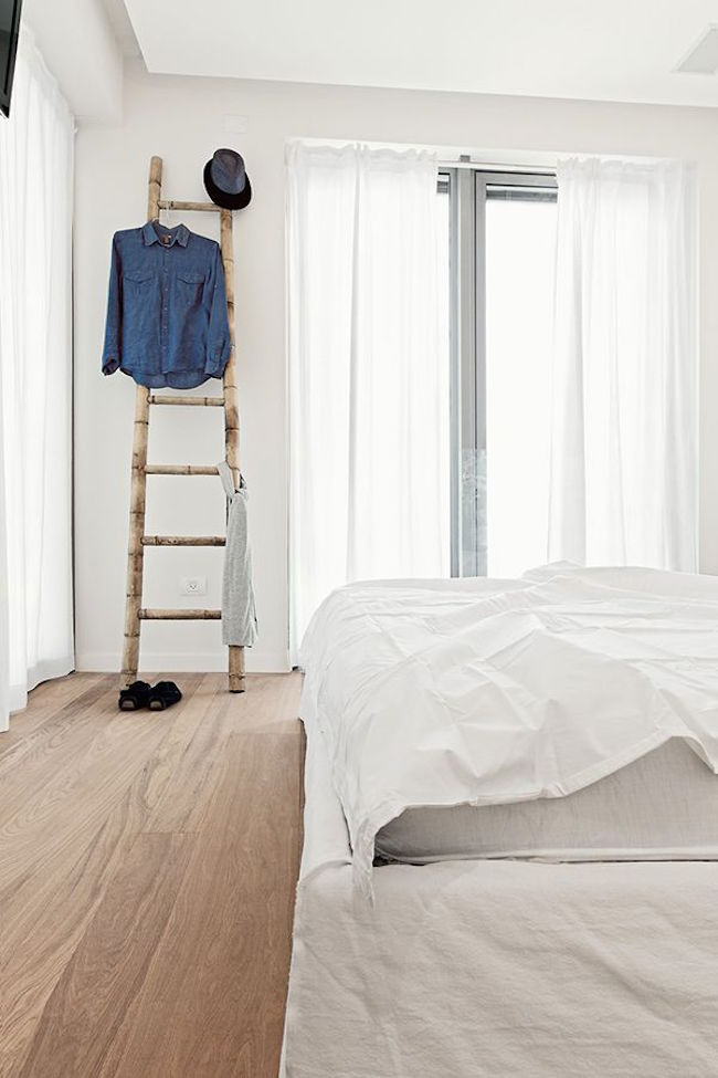 Вешалка для одежды в виде деревянной лестницы в спальне