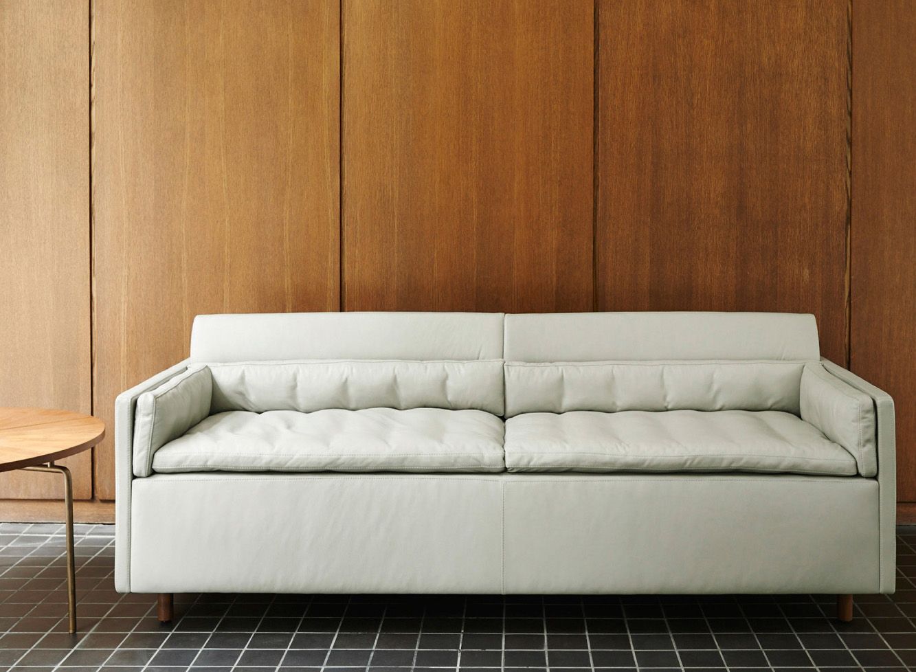 Современная модель белого дивана с деревянными ножками