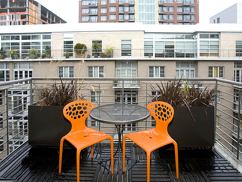 Оранжевые стулья у столика на балконе