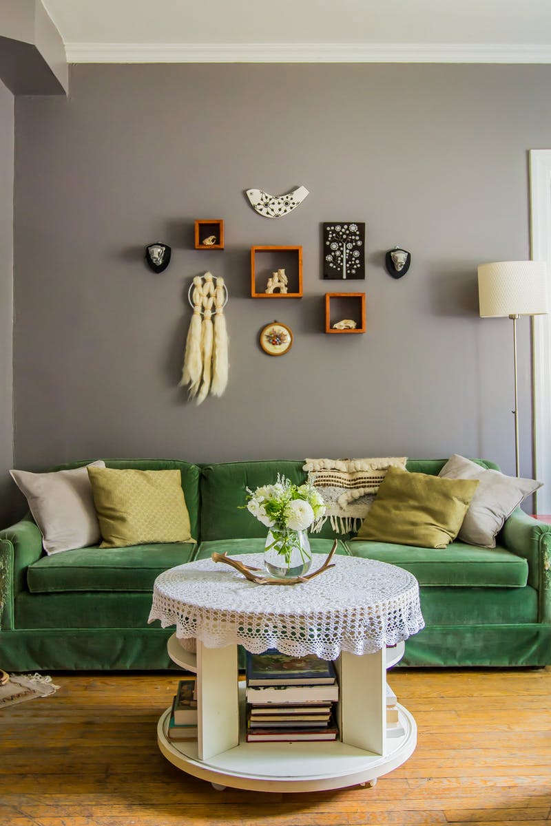Интерьер светлой гостиной в винтажном стиле с диваном зеленого цвета